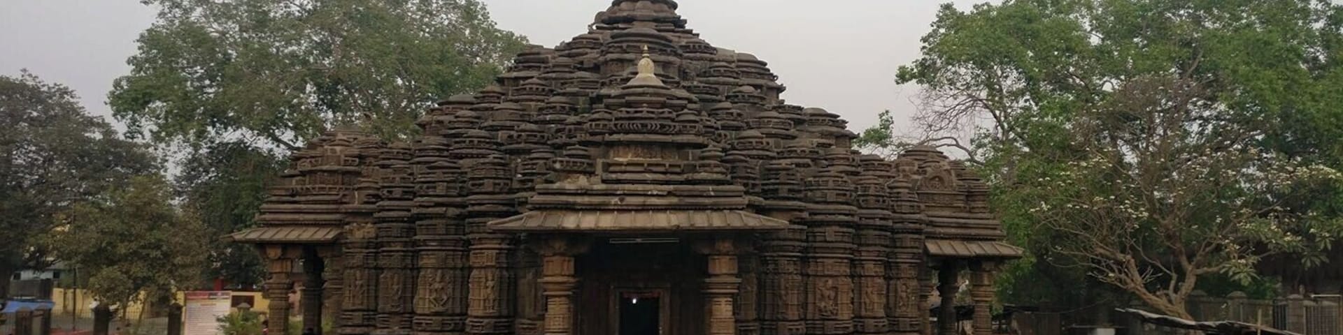 A stone temple with intricate carvings and a flag on top.