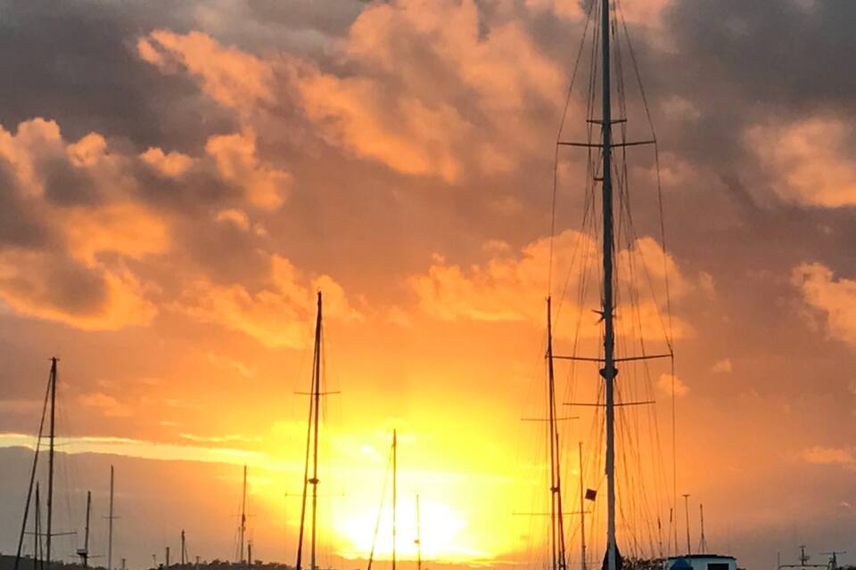 Una marina con barche a vela al tramonto.