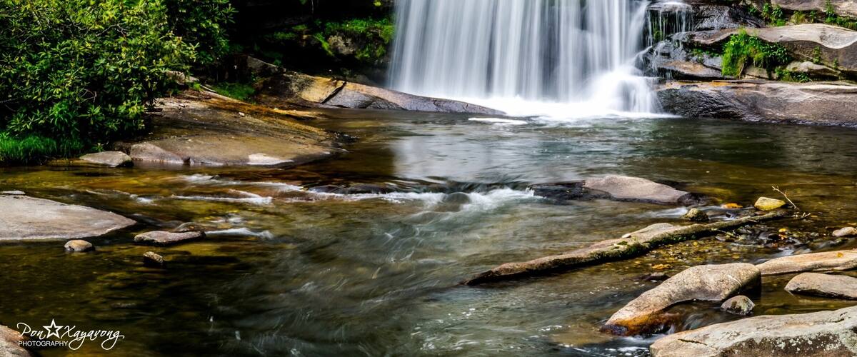 A waterfall cascading over rocks in a forested area.