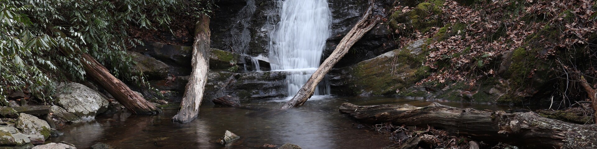 A waterfall cascading over rocks in a forested area.