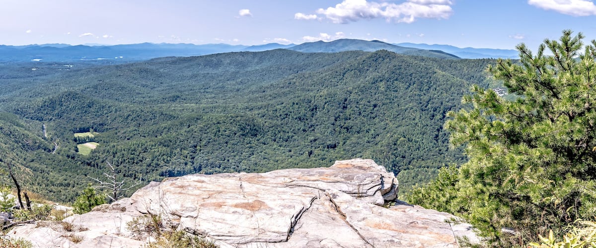 A mountainous landscape with dense forests and rocky outcrops.
