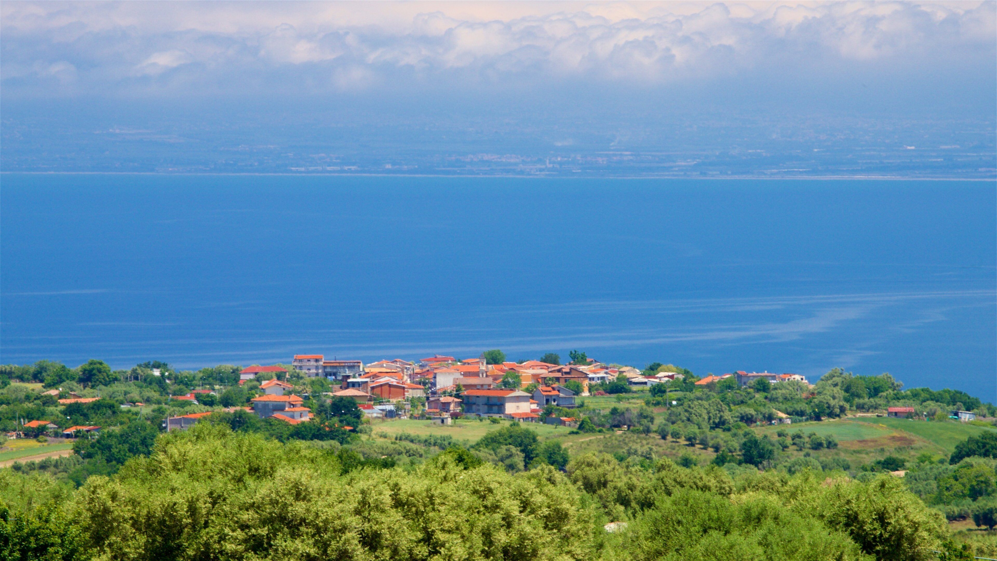 A coastal town with red-roofed houses and a view of the sea.