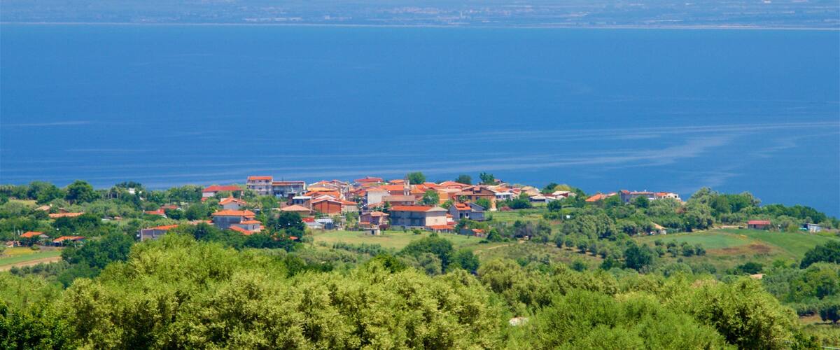A coastal town with red-roofed houses and a view of the sea.