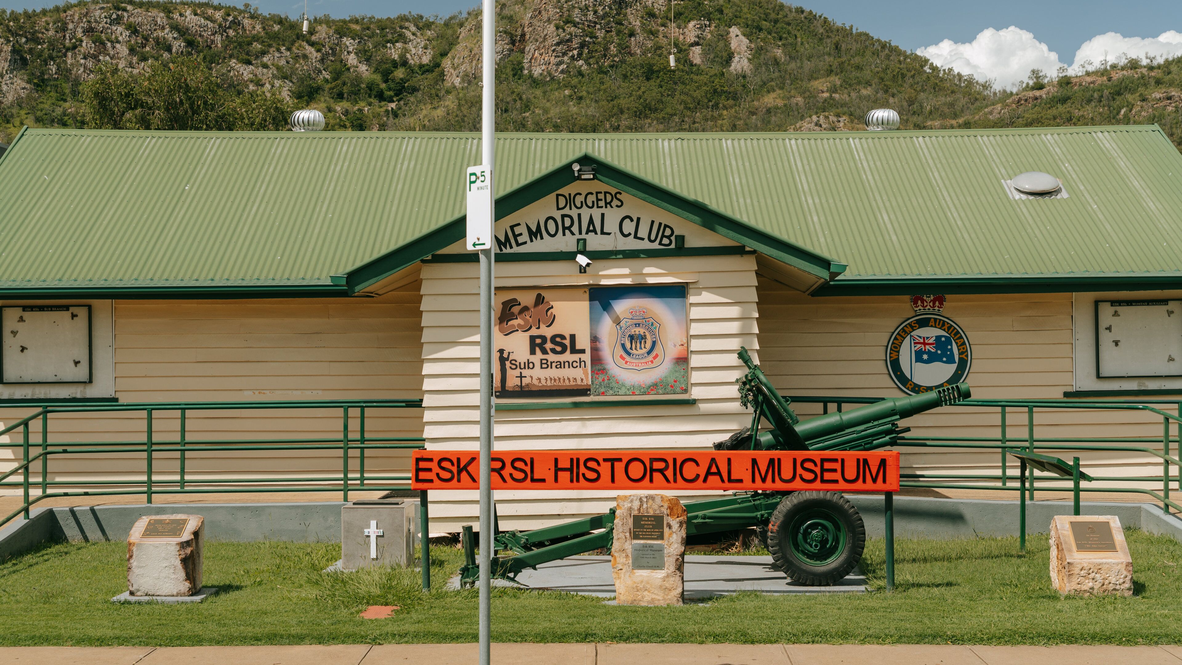 The Esk RSL Historical Museum with a green roof, a sign for the Diggers Memorial Club, and a display of military equipment.