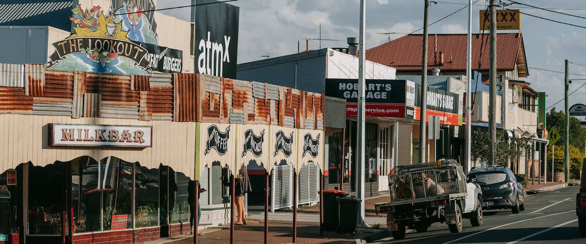 A street with buildings, including a bar named 'Milkbark' and a coffee shop called 'The Lookout'.