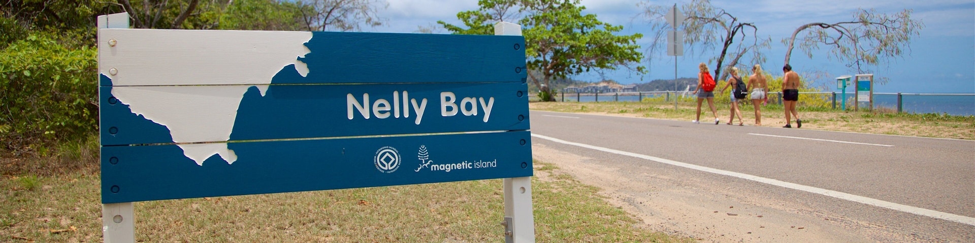 Nelly Bay which includes general coastal views and signage as well as a small group of people
