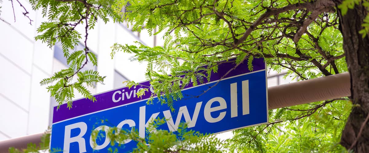 A street sign for Rockwell Avenue with a building in the background.