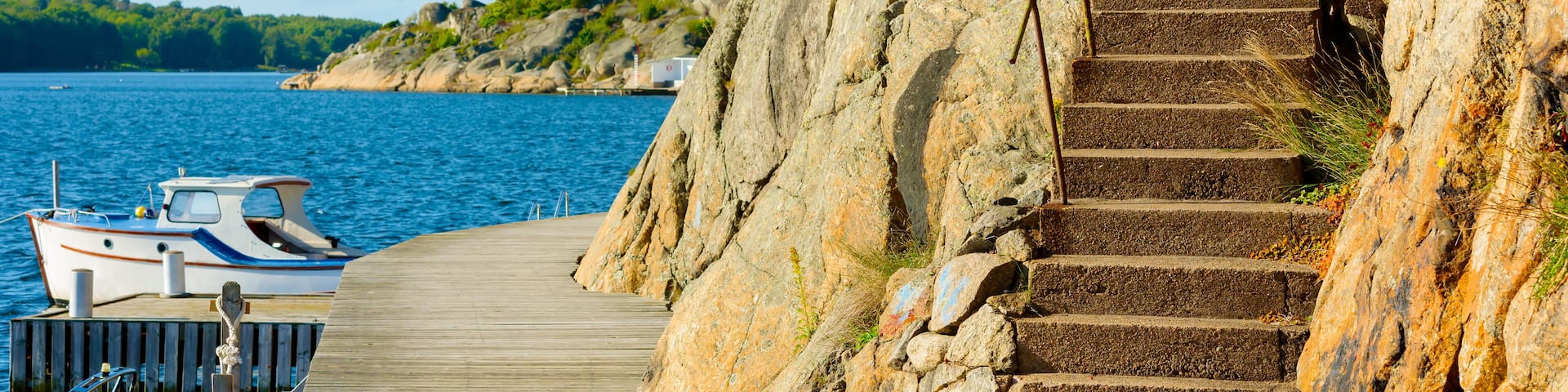Concrete steps leading up the cliff side from a coastal promenade.