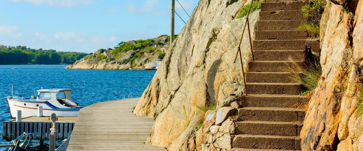 A wooden pier leading to a rocky staircase by the sea.