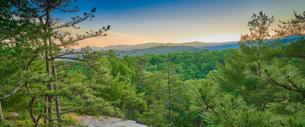 Exposed rock face with large boulder at sunset.
