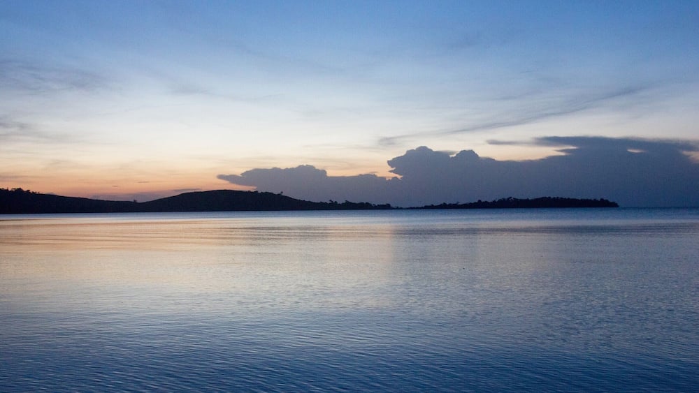 Une étendue d'eau calme, avec une rive lointaine et un ciel dégagé.