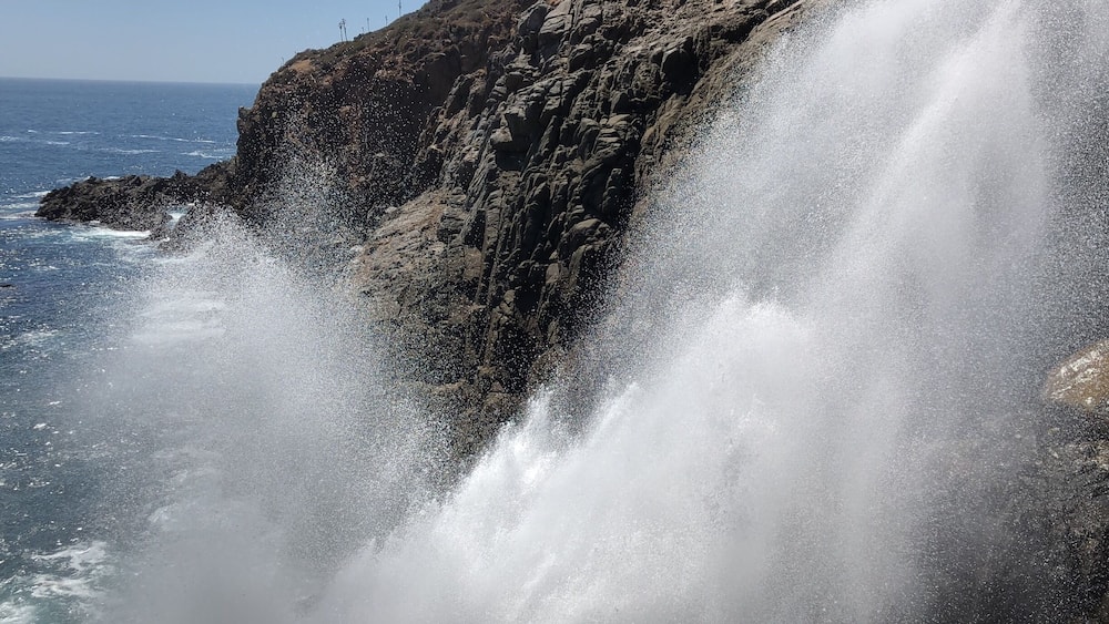 Eine Küstenklippe mit einem mächtigen Wasserfall.