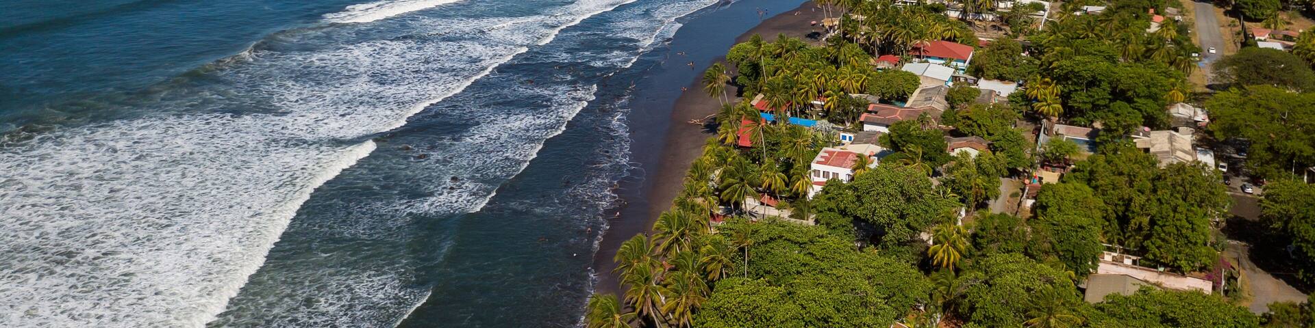 An aerial view of houses and coastline along the Majahual beach in La Libertad, El Salvador