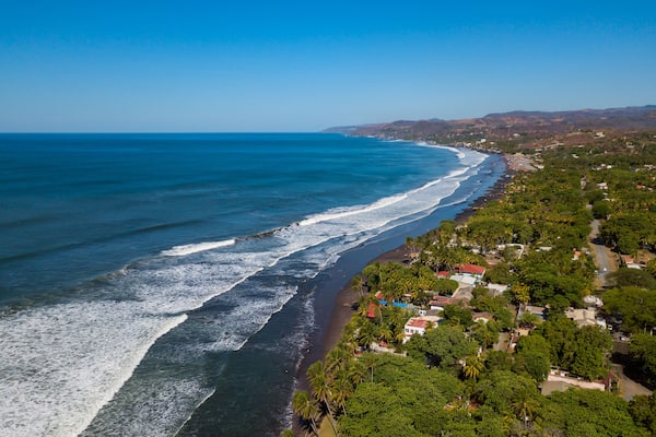 An aerial view of houses and coastline along the Majahual beach in La Libertad, El Salvador
