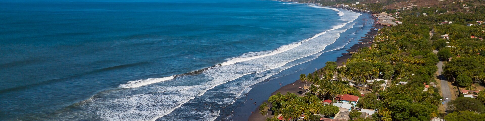 An aerial view of houses and coastline along the Majahual beach in La Libertad, El Salvador