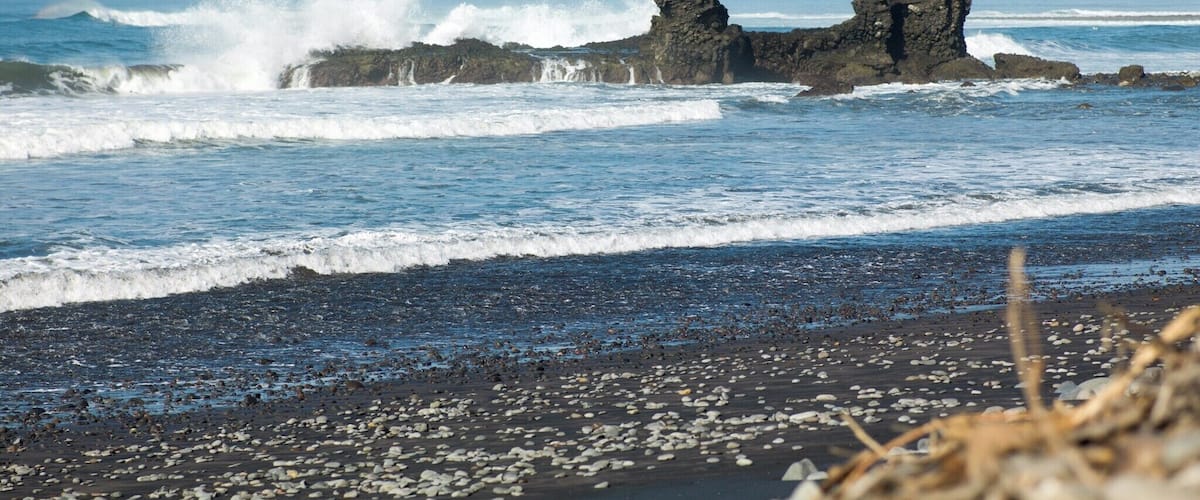 Una costa rocosa con olas rompiendo contra las rocas.