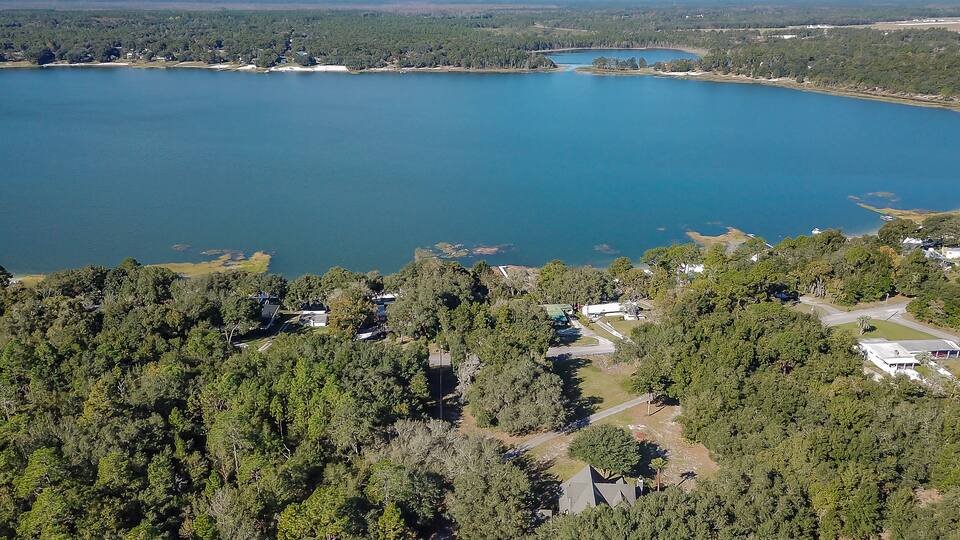 A lake surrounded by dense forest and residential areas.