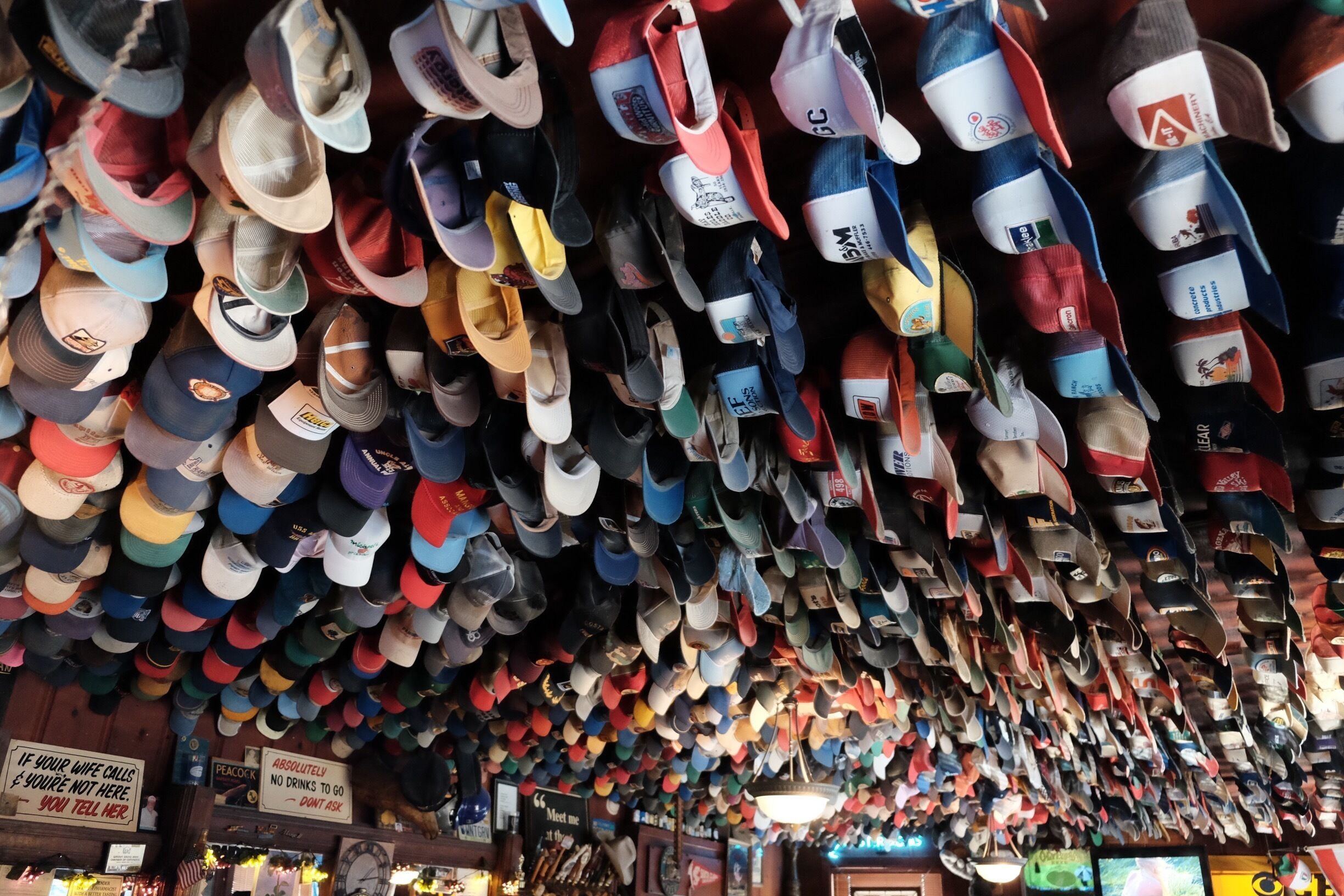 A store with numerous hats hanging from the ceiling.