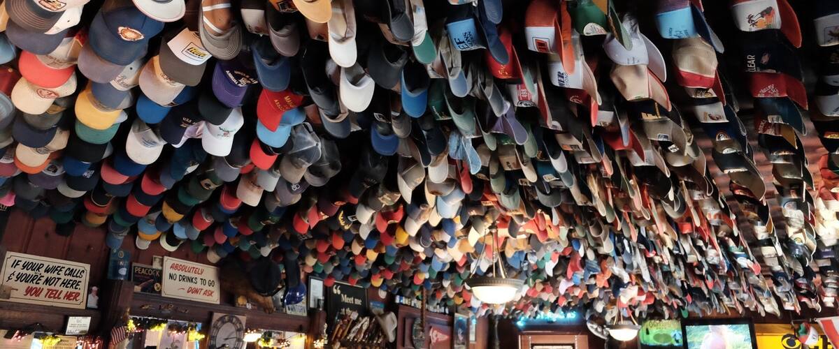 A store with numerous hats hanging from the ceiling.