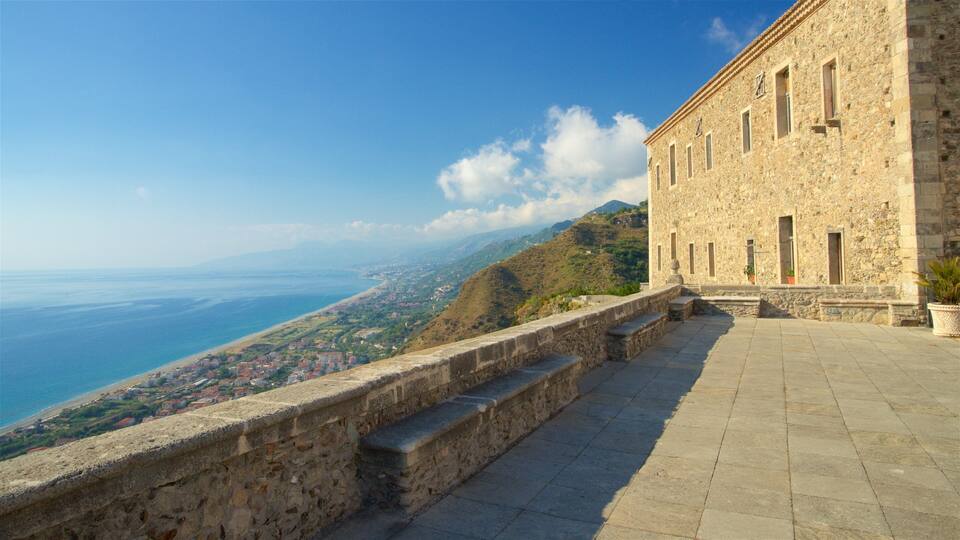 A stone building with a view of a coastal town and the sea.