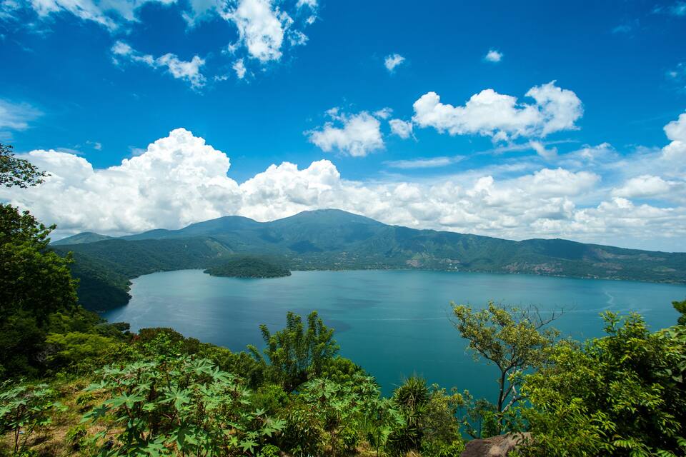 A lake surrounded by mountains and a clear blue sky.