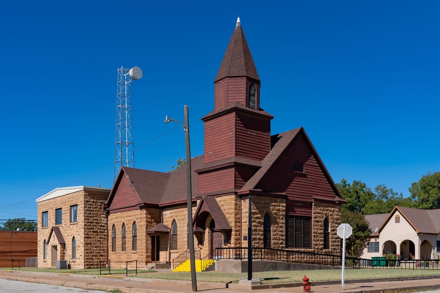 Une église dotée d’un clocher élancé et d’une tour horloge.