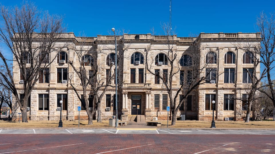 A historic stone building with arched windows and a central entrance.