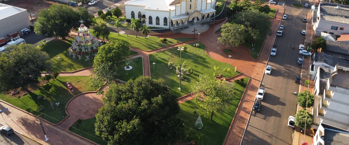 An aerial view of a city with a prominent church, green spaces, and a busy street.