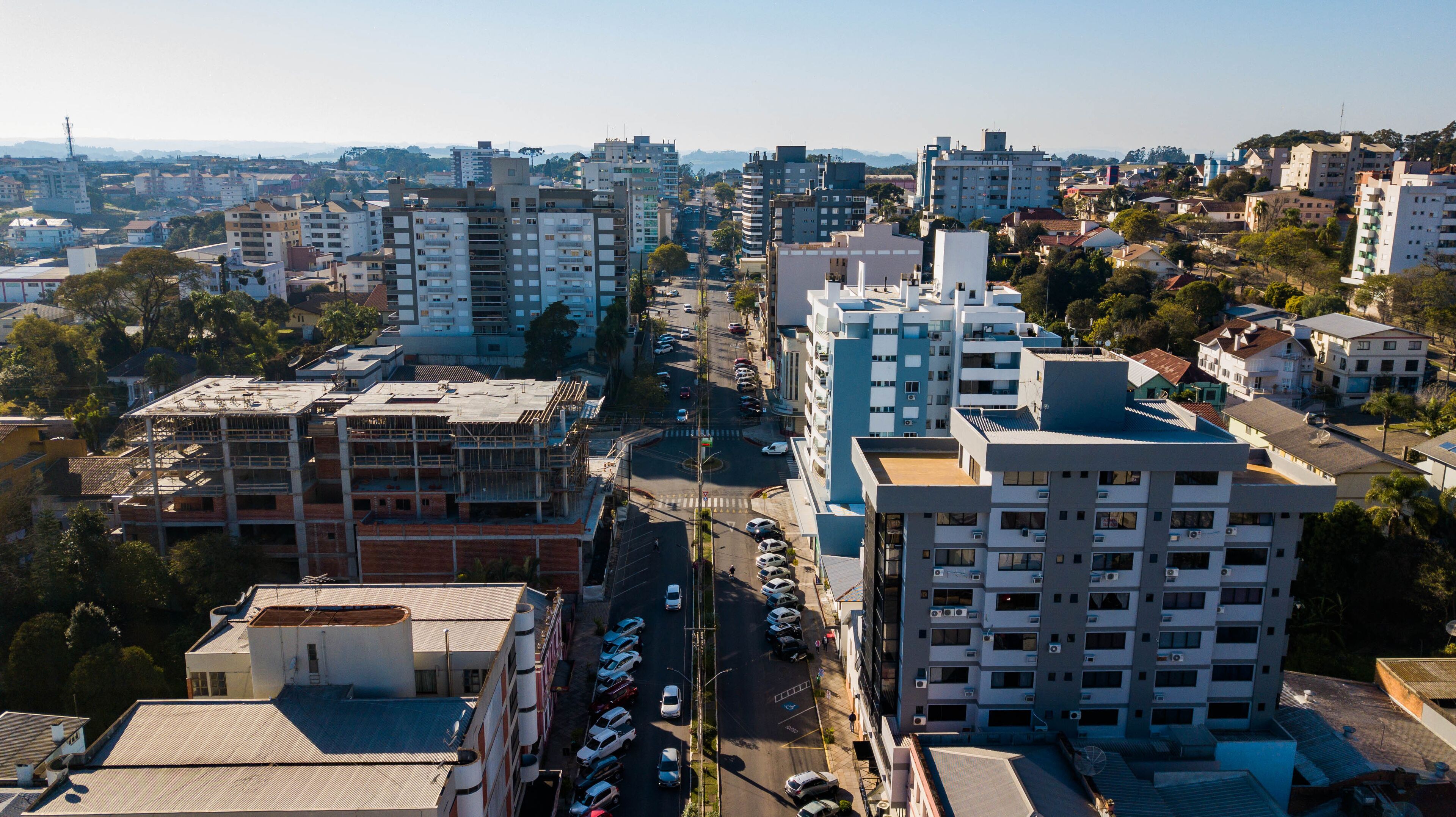 A cityscape with various buildings, roads, and a clear sky.