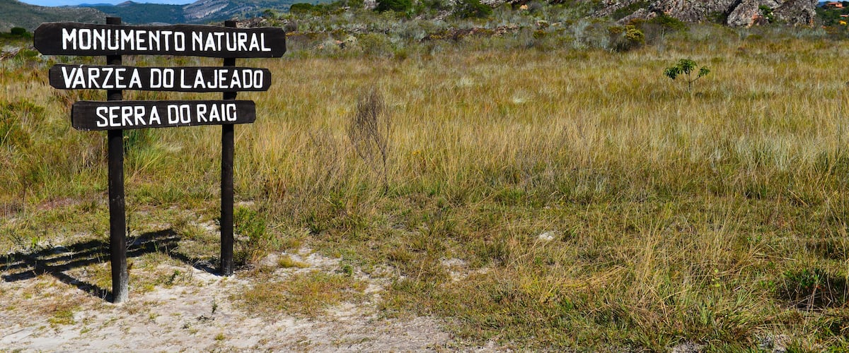 A sign in the rocky cerrado landscape of the Serra do Espinhaço, on a trail to the Lajeado waterfall, Várzea do Lajeado e Serra do Raio Natural Monument, Milho Verde, Minas Gerais, Brazil