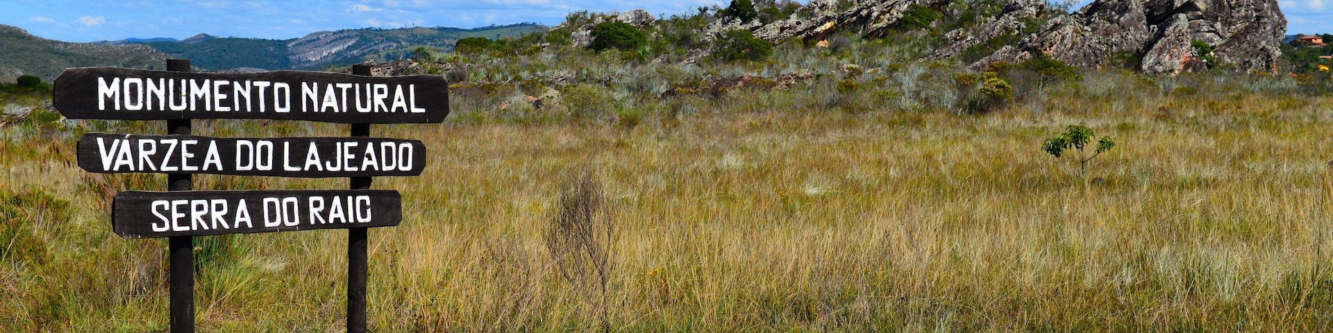 A sign in the rocky cerrado landscape of the Serra do Espinhaço, on a trail to the Lajeado waterfall, Várzea do Lajeado e Serra do Raio Natural Monument, Milho Verde, Minas Gerais, Brazil