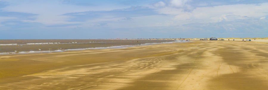 People, cars and sand in Cassino beach