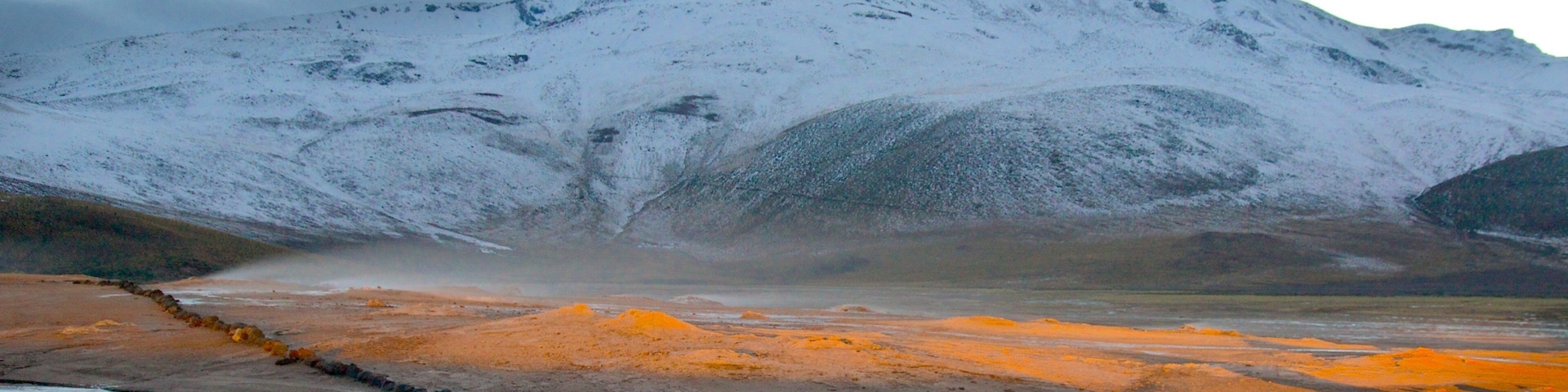 El Tatio Geyser Field which includes a sunset, mountains and snow