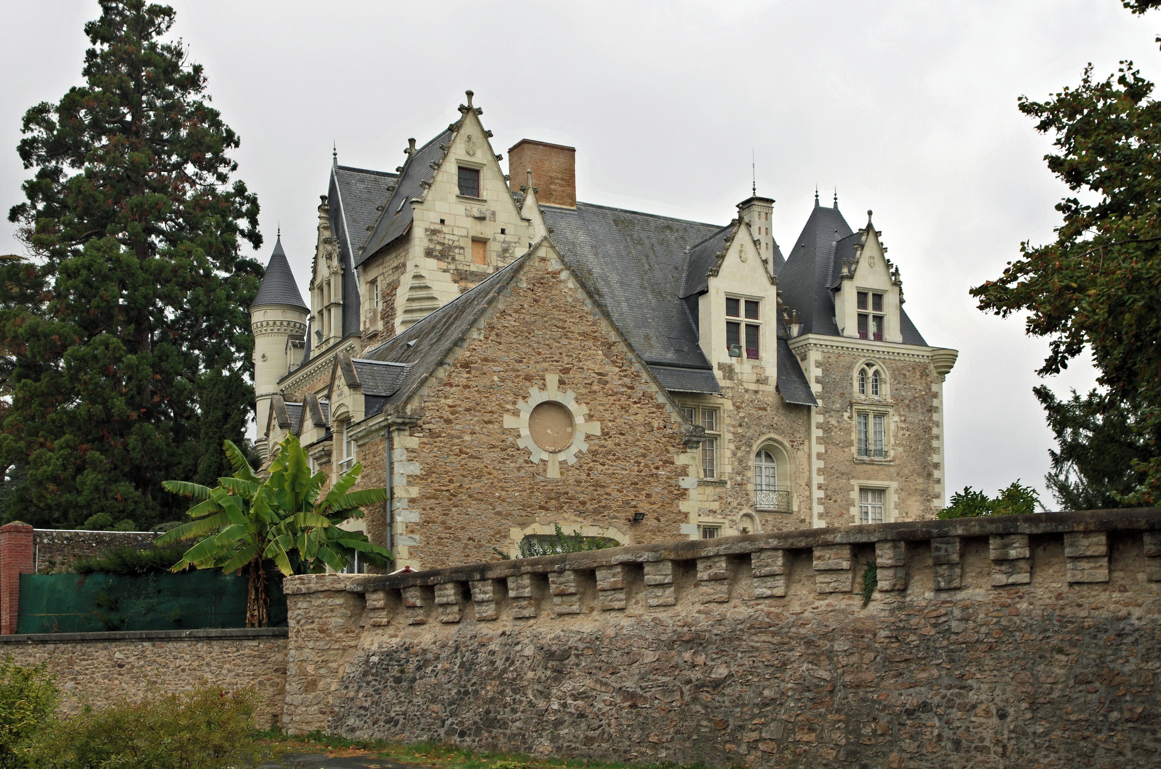 A historic stone building with multiple towers and a large circular window.