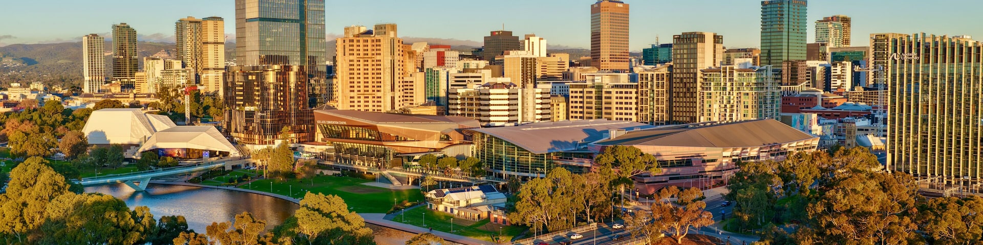 Adelaide City, South Australia – 4K aerial drone footage of CBD skyline, Towers, River Torrens, Convention Centre, Elder Park, city bridges and golden sunset cityscape.