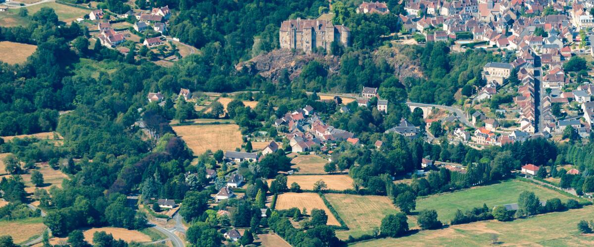 A rural landscape with a castle, fields, and scattered houses.