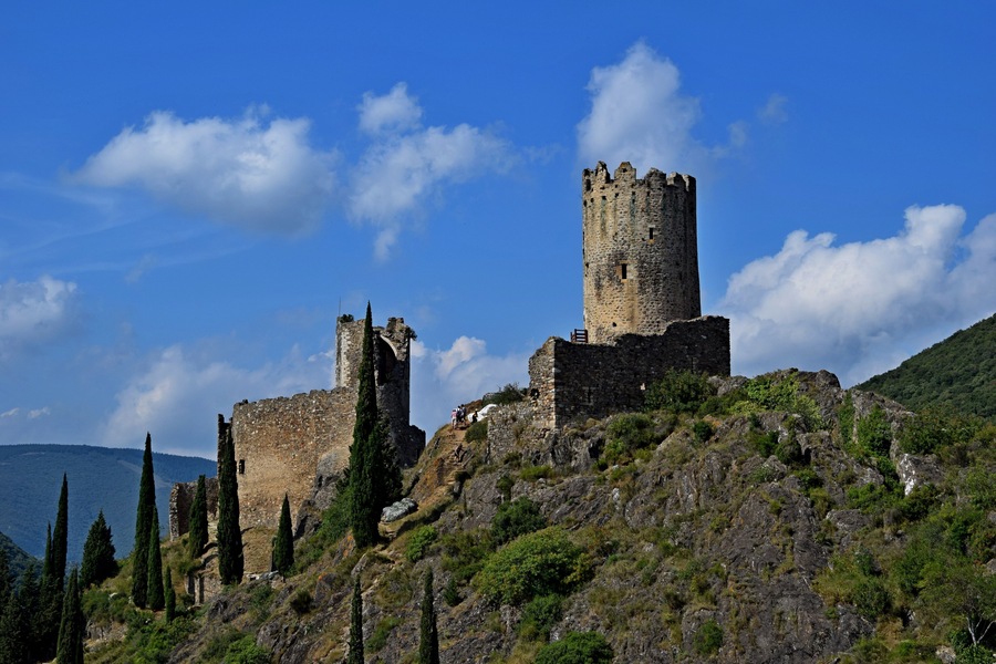 A medieval castle on a hill with clear skies.