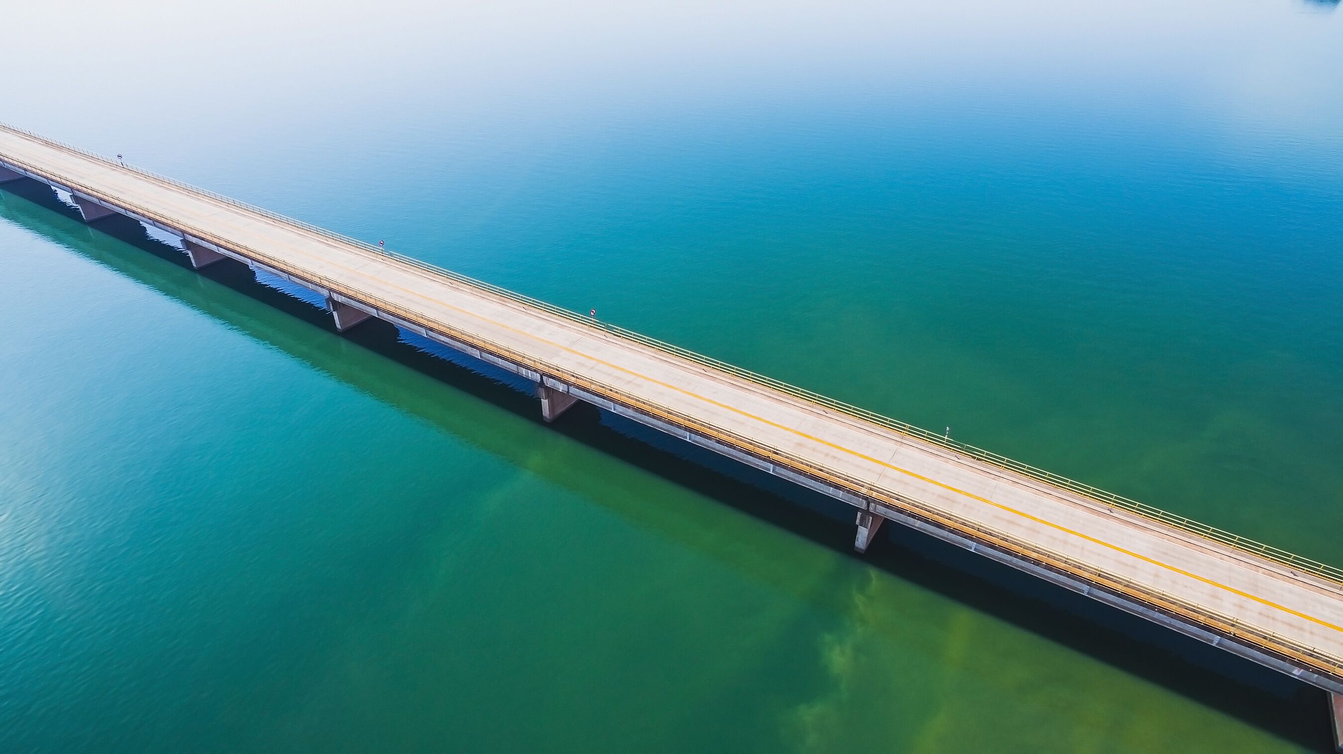 Aerial view of a long highway bridge above a river. Bridge Helio Serejo over the Parana river on the borders between Mato Grosso do Sul and Sao Paulo states in Brazil.