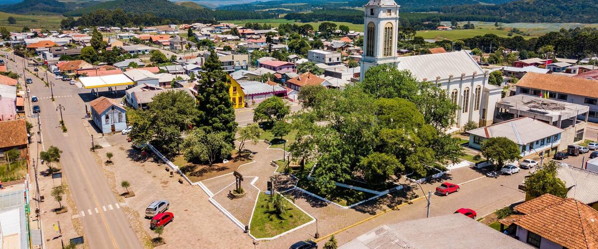A town with a prominent church tower, a central plaza, and surrounding residential buildings.