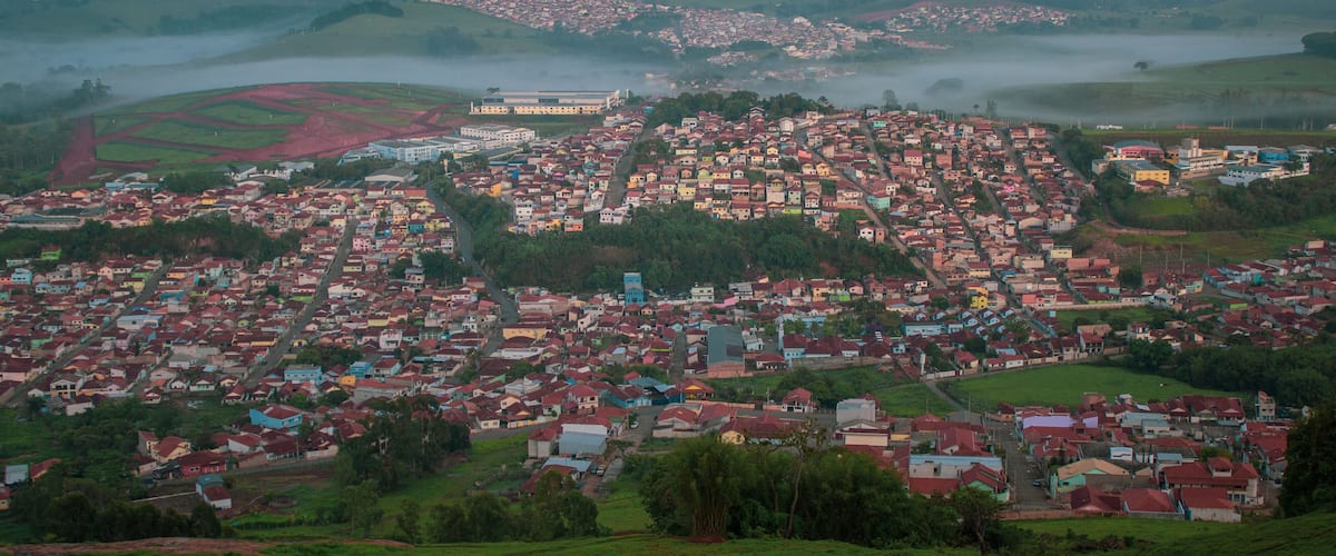 A town with colorful houses and a large building in the distance.