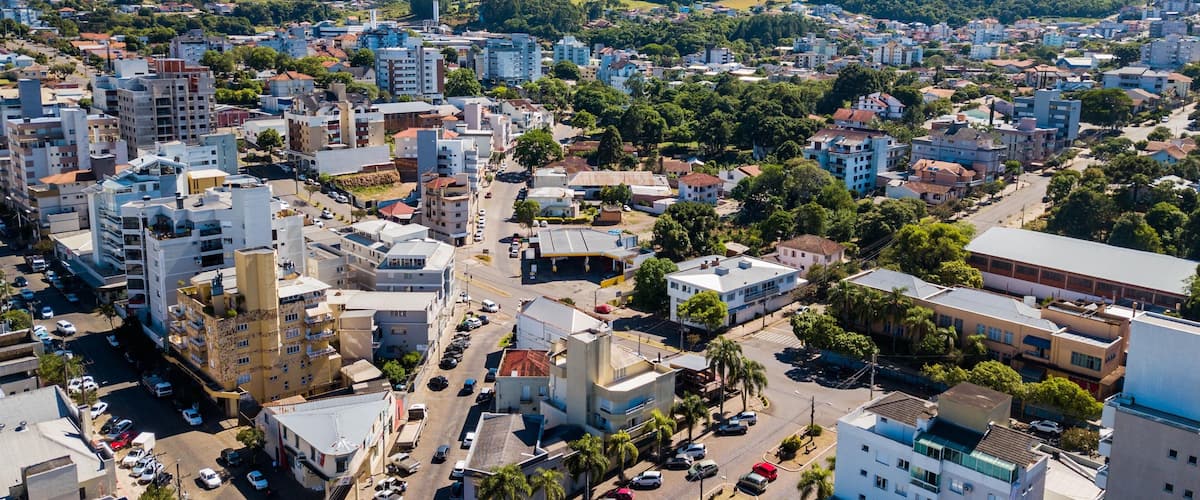 A cityscape with dense urban buildings, a central road, and surrounding greenery.
