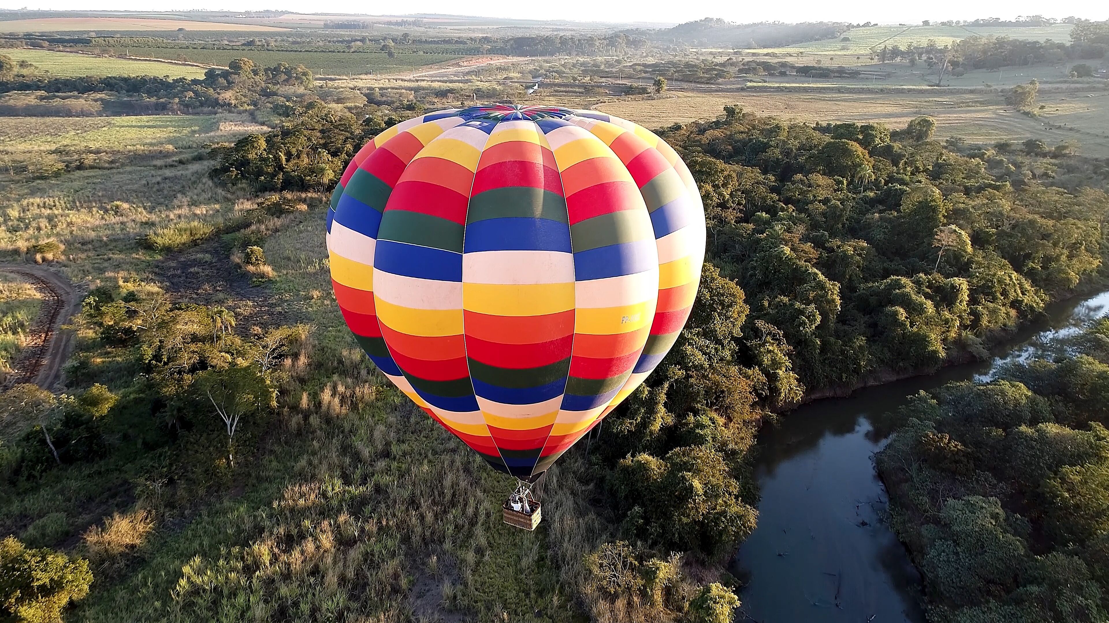Panorama landscape of isolated hot air balloon at countryside scenery. Colorful hot air balloon aerial view. Balloon in the air. Rural forest landscape. Sport adventure ballooning.