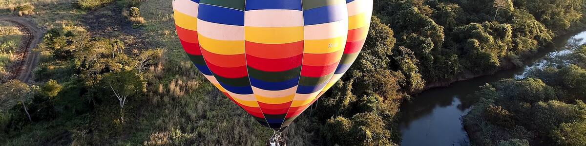 Panorama landscape of isolated hot air balloon at countryside scenery. Colorful hot air balloon aerial view. Balloon in the air. Rural forest landscape. Sport adventure ballooning.