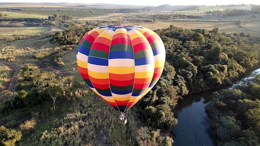Panorama landscape of isolated hot air balloon at countryside scenery. Colorful hot air balloon aerial view. Balloon in the air. Rural forest landscape. Sport adventure ballooning.