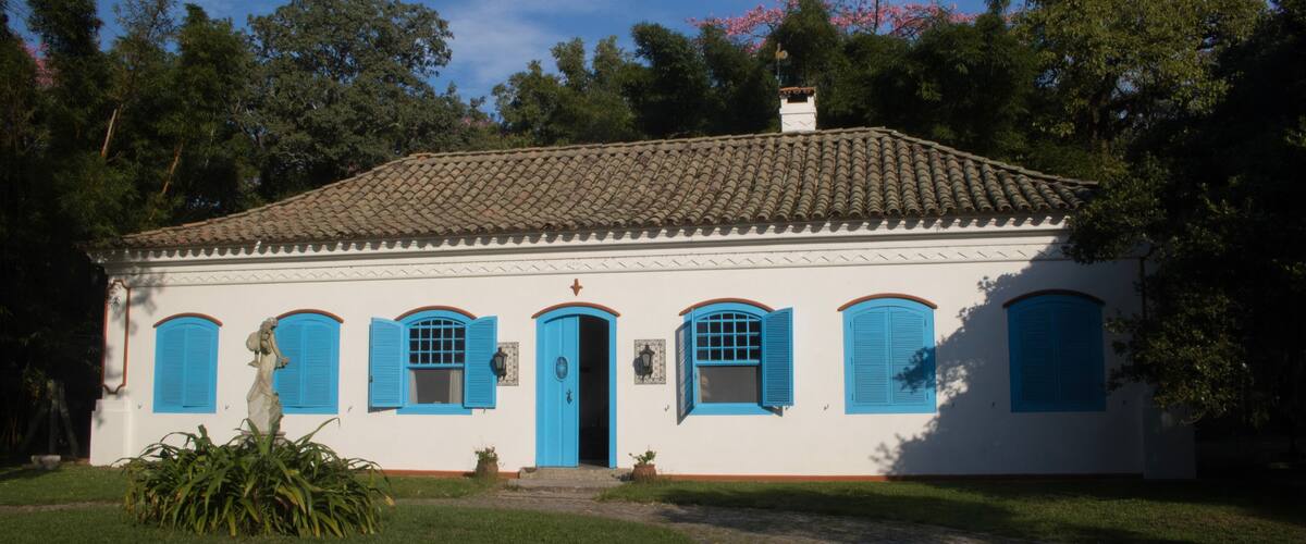 A white building with blue shutters and a tiled roof.