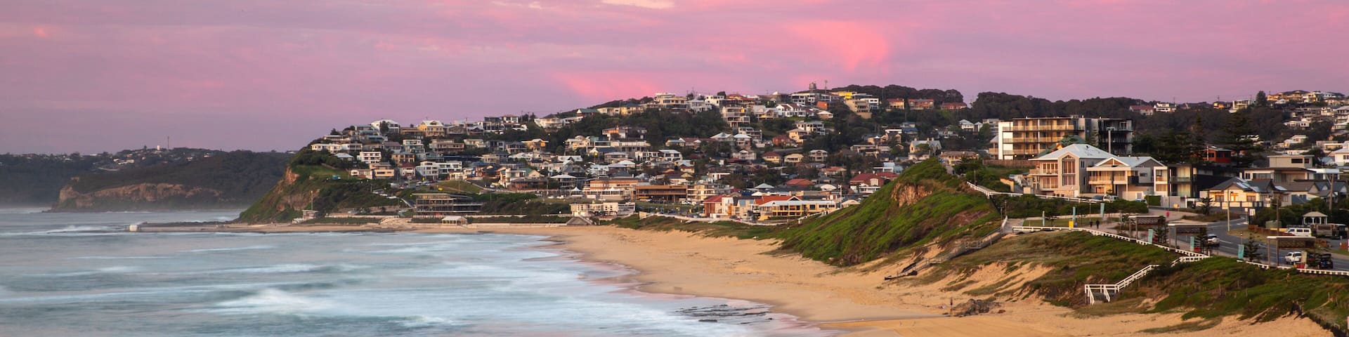 Bar Beach featuring a sandy beach, a coastal town and a sunset