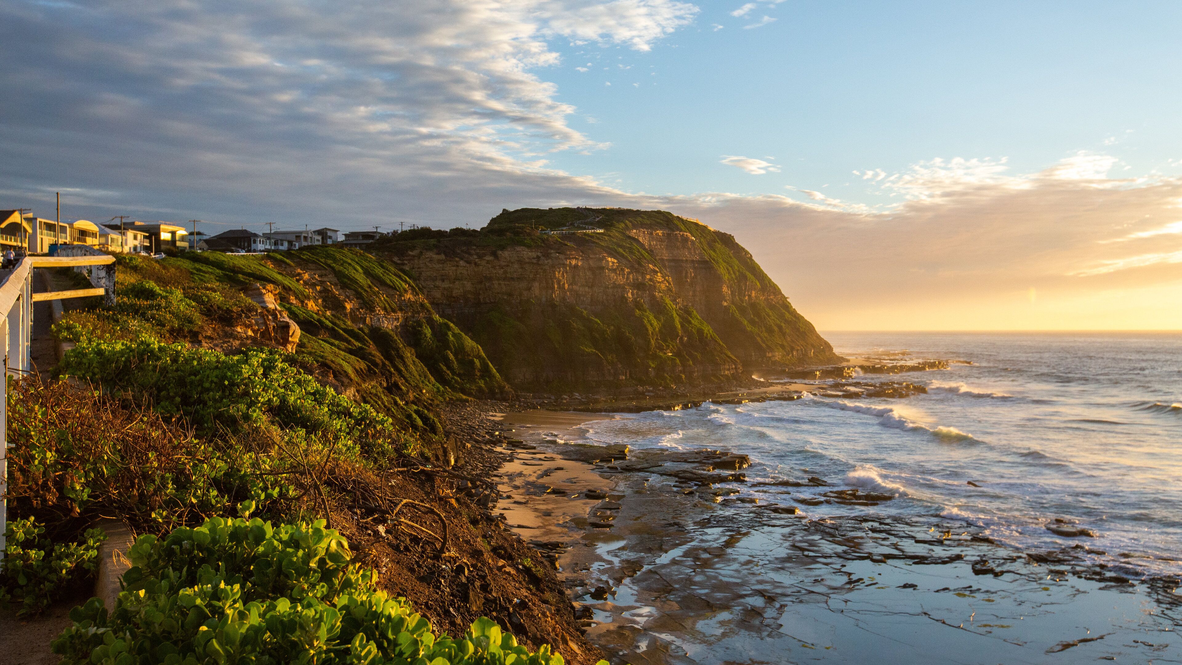 Bar Beach which includes rocky coastline, a sunset and general coastal views