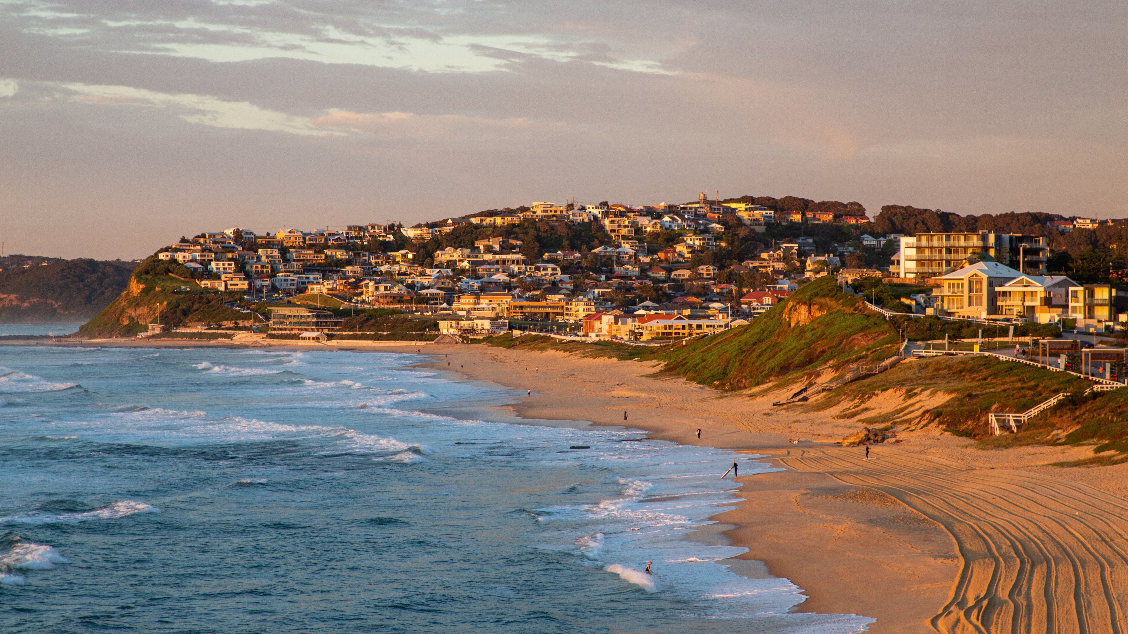 Uma cidade costeira com praia e ondas do oceano.