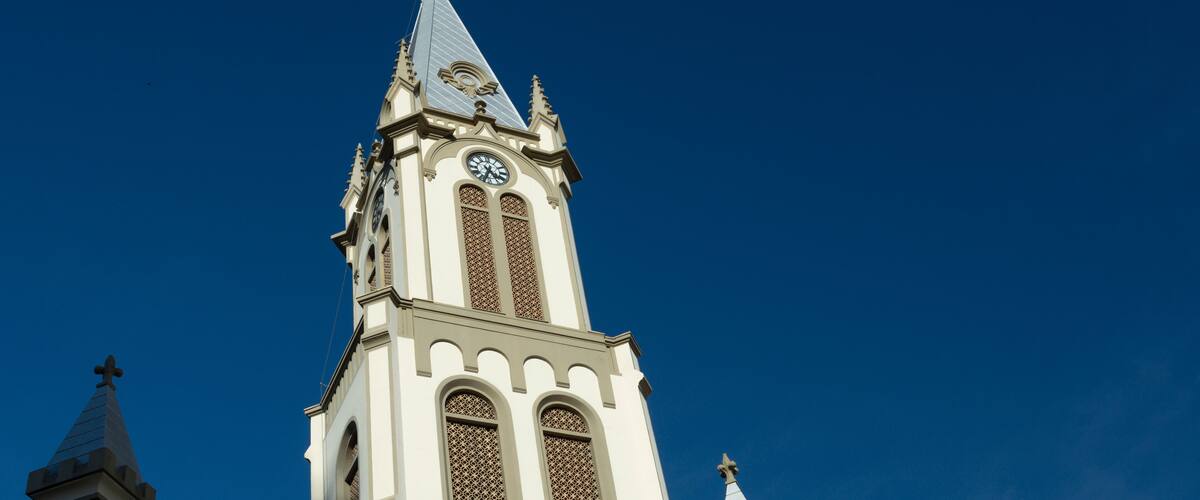A church with a tall steeple and a clock.