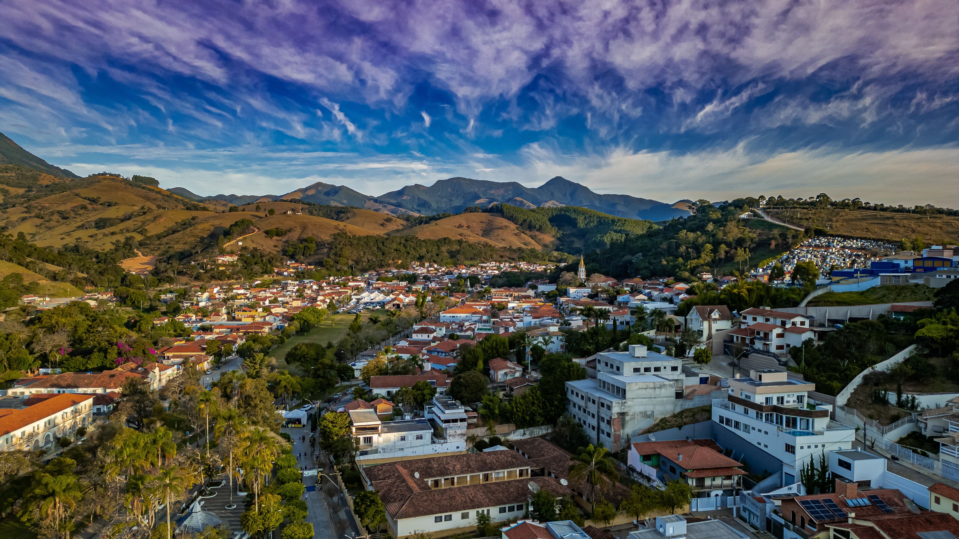 A town nestled in a valley with mountains in the background.